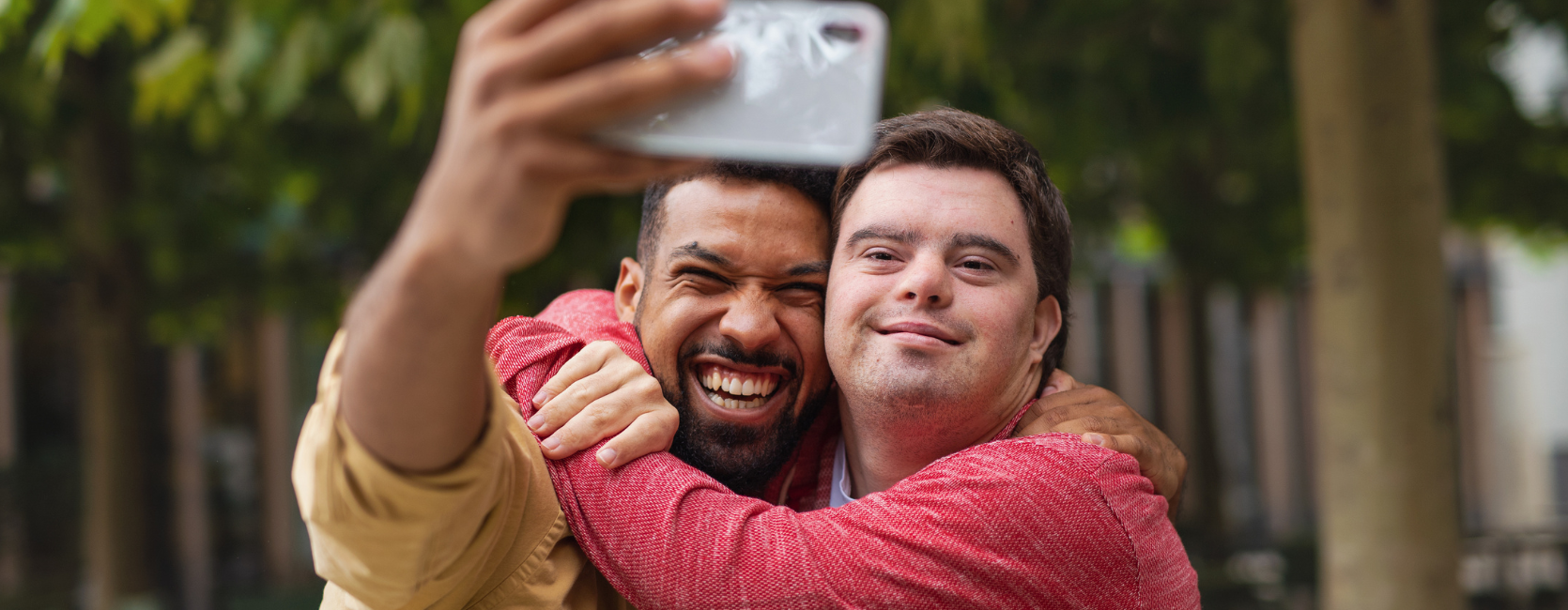 Ein Mann macht ein gemeinsames Selfie-Bild mit einem Mann mit Down-Syndrom.