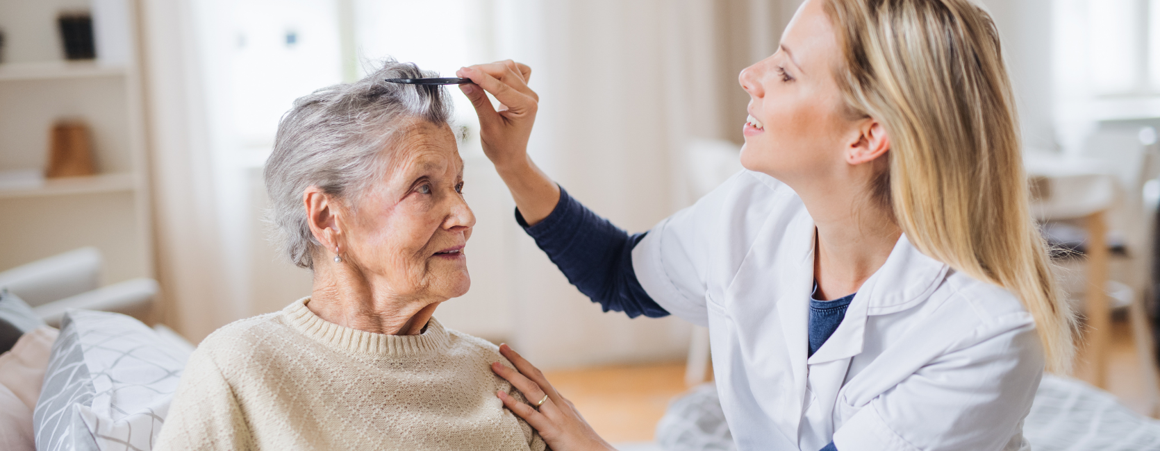 junge Pflegerin kämmt Seniorin die Haare