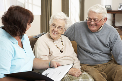 Pflegeleitung spricht mit älterem Ehepaar
