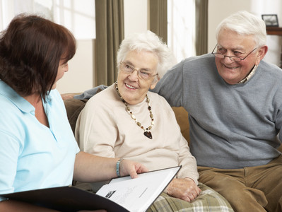 Pflegeleitung spricht mit älterem Ehepaar