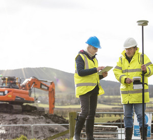 Ein Vermessungsteam kartiert mit einer intelligenten Antenne eine Baustelle
