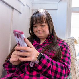 Eine Frau mit Down Syndrom benutzt ein Smartphone