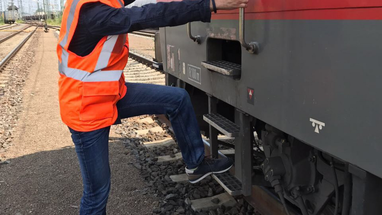 Staatssekretär David Langner besteigt die Elektrolokomotive der Baureihe 185 und begleitet das Fahrpersonal des mit Containern beladenen Güterzugs auf der Strecke von Mainz-Bischofsheim nach Köln.